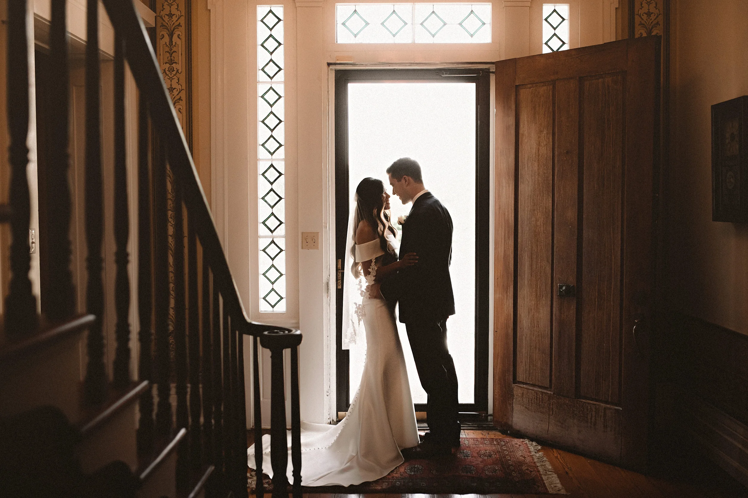 Bride and groom standing in the historic foyer of the Denny House on their wedding day.